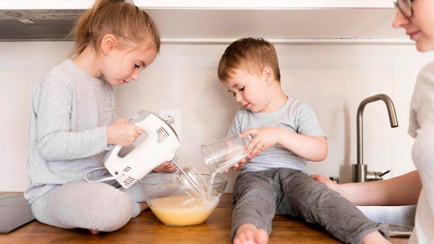 Foto gratuita vista frontale dei fratelli che cucinano a casa