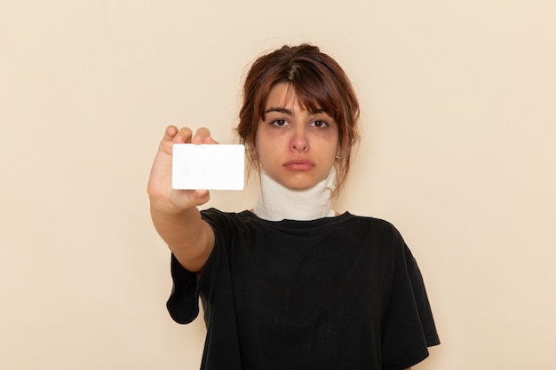 Front view sick young female feeling ill holding white card on white surface