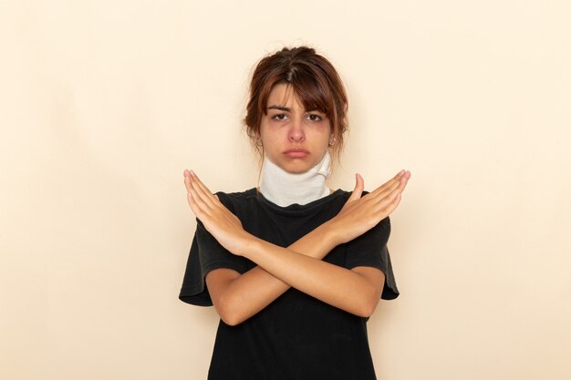 Front view sick young female with high temperature and feeling ill crossing her arms on white surface