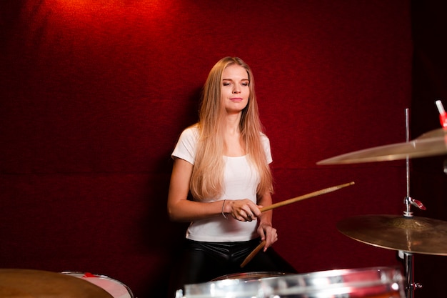 Front view sideways girl playing drums