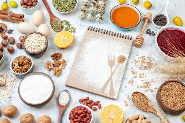 Front view simple notepad with eggs flour jelly and different nuts on white background nut sugar color pie photo fruit sweet cake dough