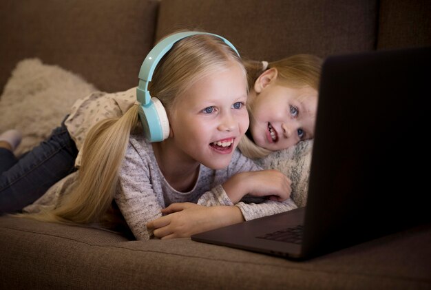 Front view of sisters on couch with a laptop