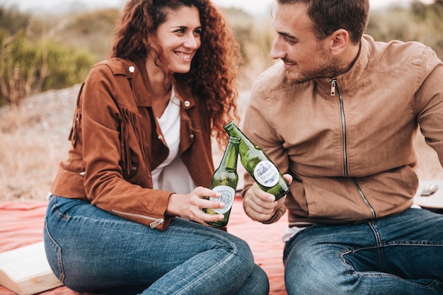 Front view sitting couple drinking beer