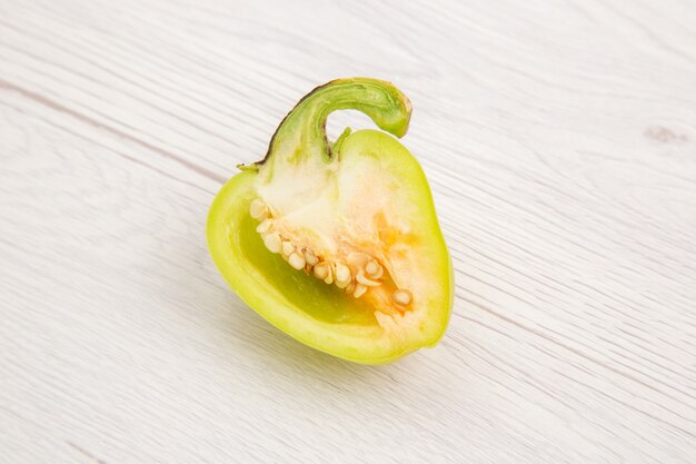 正面図スライスしたピーマン白い机の上の緑のスパイシーな熱い野菜の熟したカラー写真