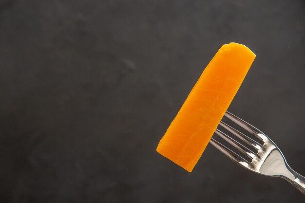 Front view sliced cheese on fork on dark desk meal color photo snack breakfast crisp