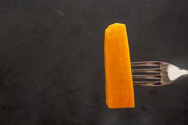 Front view sliced cheese on fork on a dark meal color photo snack breakfast crisp