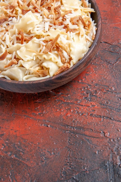 Front view sliced cooked dough with rice on the dark surface pasta dish dough meal