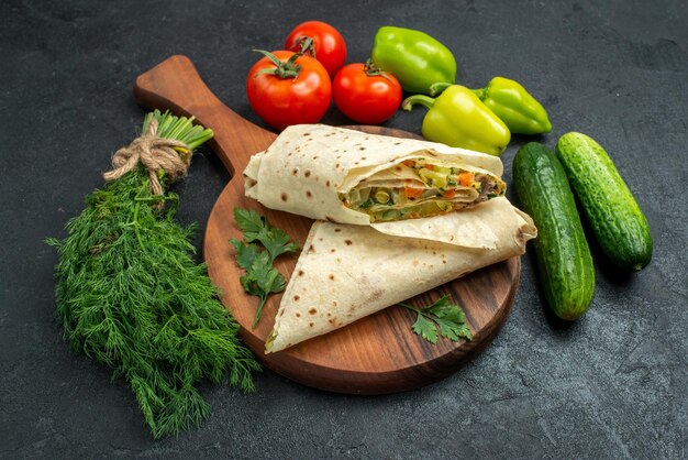 Вид спереди нарезанная вкусная шаурма со свежими овощами на серой поверхности салат, бургер, сэндвич, еда, закуска