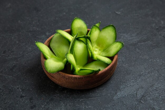 Front view sliced designed cucumbers inside pot on grey space