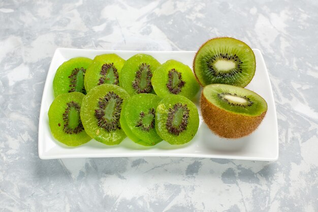 Front view sliced fresh kiwis inside plate on light white surface