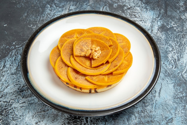 Front view of sliced persimmon with pancake on light surface