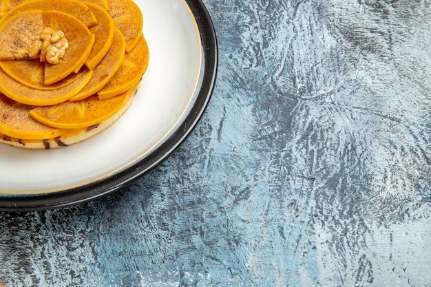 Front view of sliced persimmon with pancake on light surface