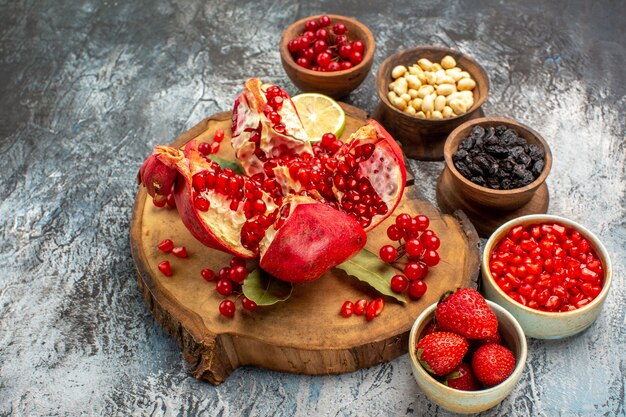 Front view sliced pomegranates with other fruits on light-dark table tree garden fruit