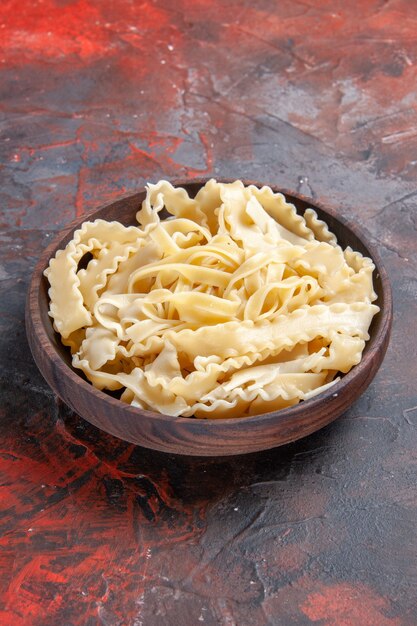 Front view sliced raw dough inside plate on a dark surface dough pasta raw dark food