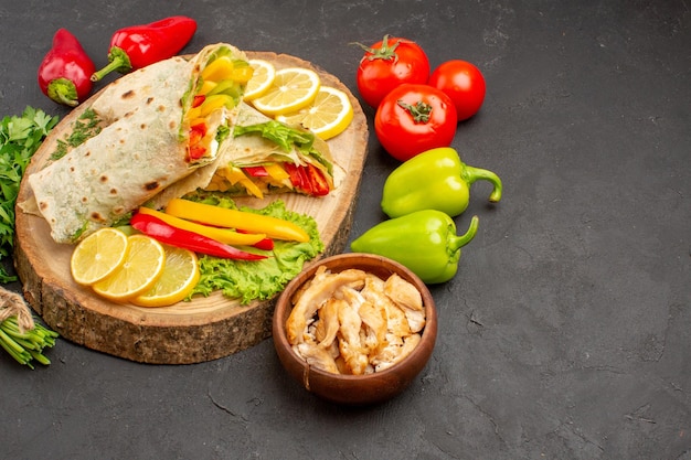 Panino di carne shaurma affettato vista frontale con fette di limone e verdure su spazio scuro