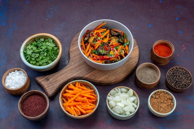 Front view sliced vegetable salad inside plate with greens seasonings on dark desk salad food meal vegetable