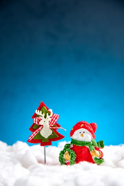 Маленькие рождественские игрушки вид спереди на синем фоне