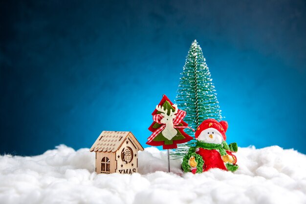 Front view small xmas toys wooden house on blue background