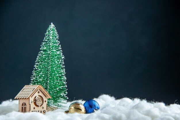 正面図小さなクリスマスツリー小さな木の家暗い表面のクリスマスツリーボール