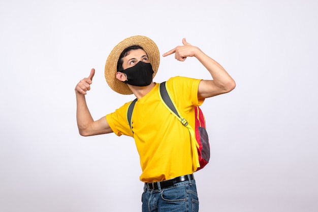 Front view smart young man with mask and yellow t-shirt pointing fingers at himself
