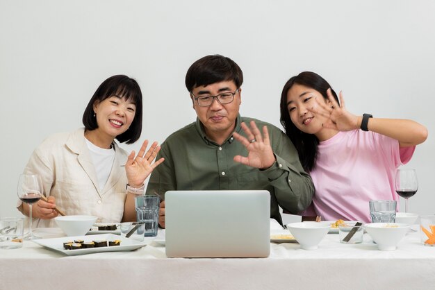 Front view smiley asian family with laptop