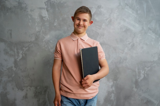 Front view smiley boy holding notebook