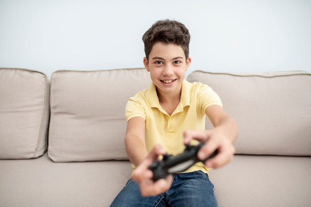 Вид спереди смайлик мальчик играет с контроллером