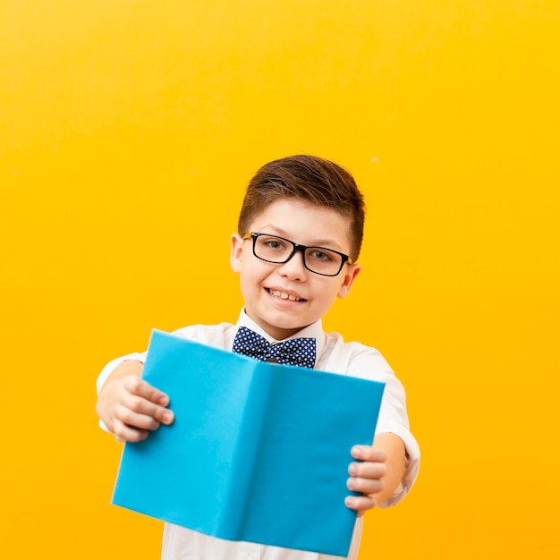 Front view smiley boy showing book