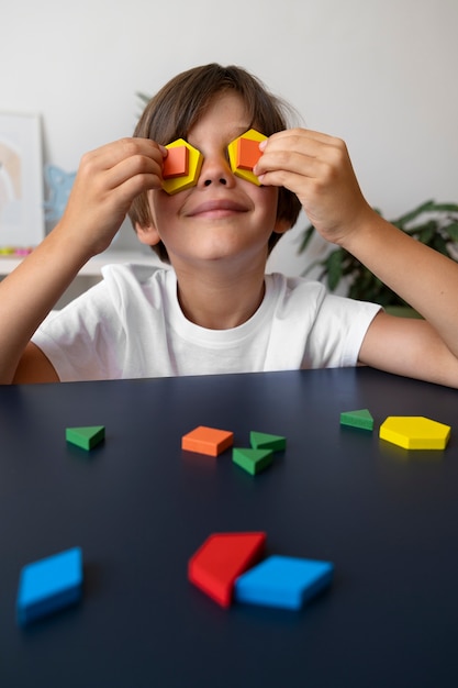 Ragazzo sorridente di vista frontale con i pezzi del puzzle