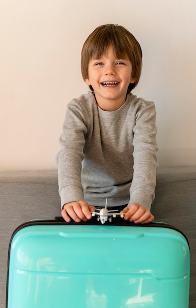 Free photo front view of smiley child with luggage