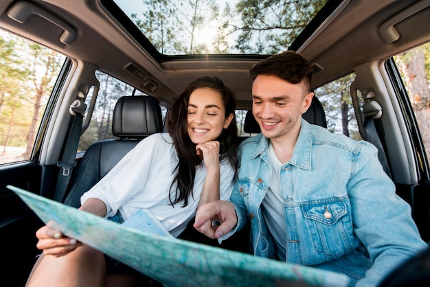 Free photo front view smiley couple holding map