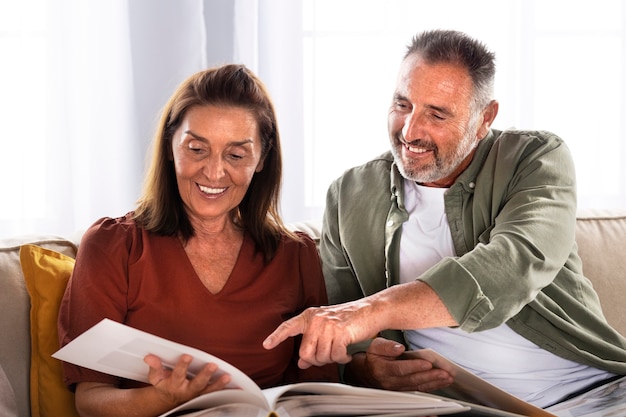 Front view smiley couple looking at picture album