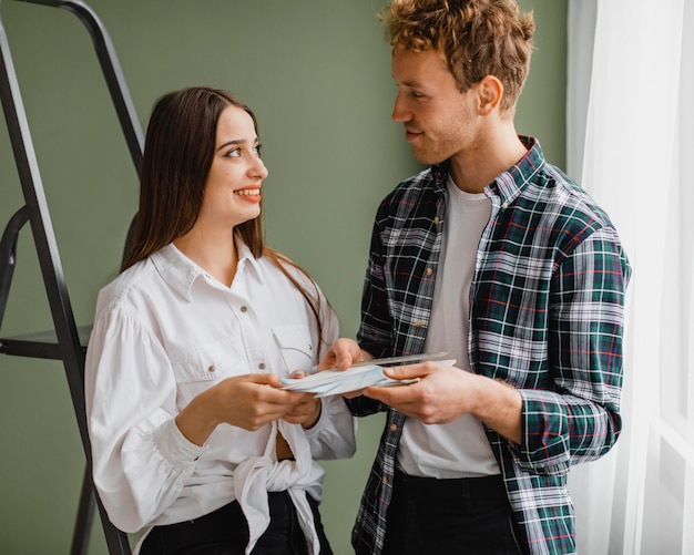 Free photo front view of smiley couple making plans to redecorate the house