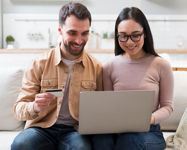 Front view of smiley couple shopping online