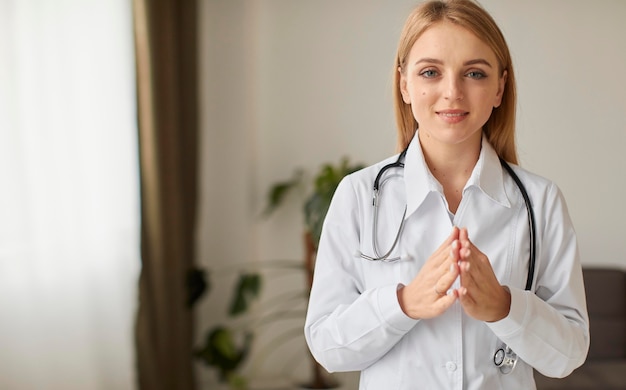 Front view of smiley covid recovery center female doctor praying