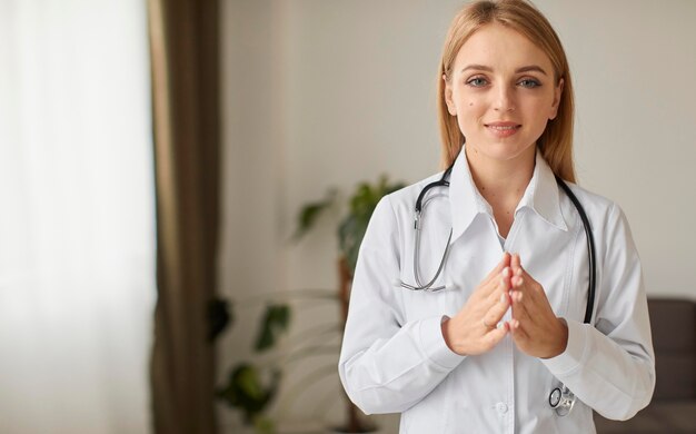 Front view of smiley covid recovery center female doctor praying