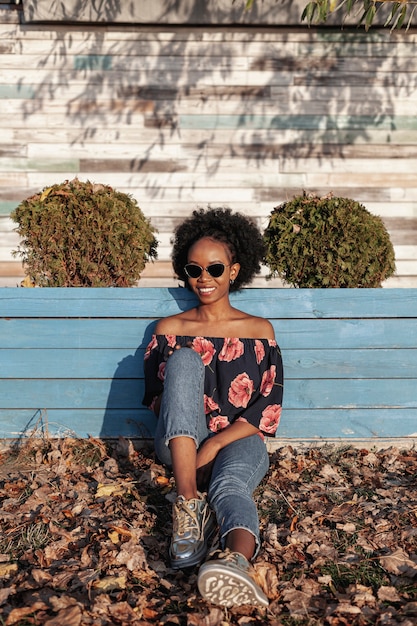 Front view smiley curly haired woman wearing sunglasses