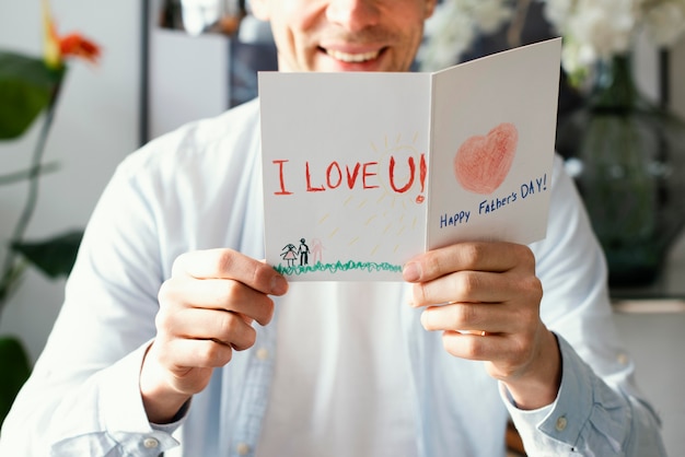 Front view of smiley father reading his father's day card