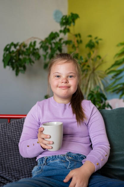 Tazza della holding della ragazza di smiley di vista frontale