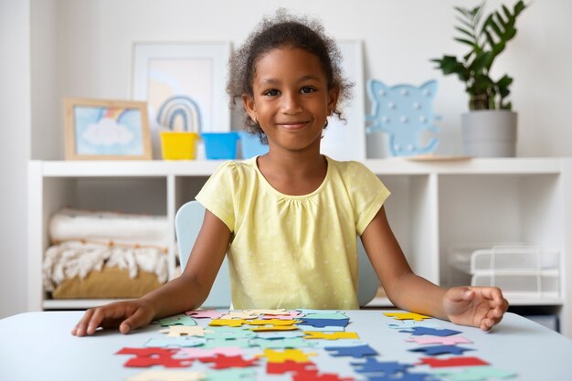 Front view smiley girl making puzzle