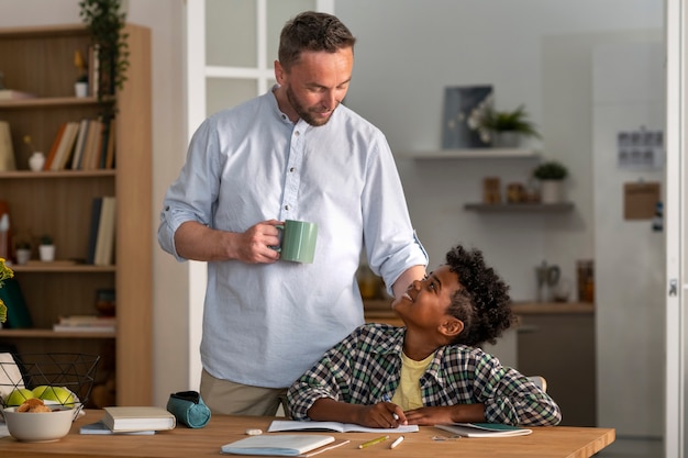 Free photo front view smiley kid and father at home