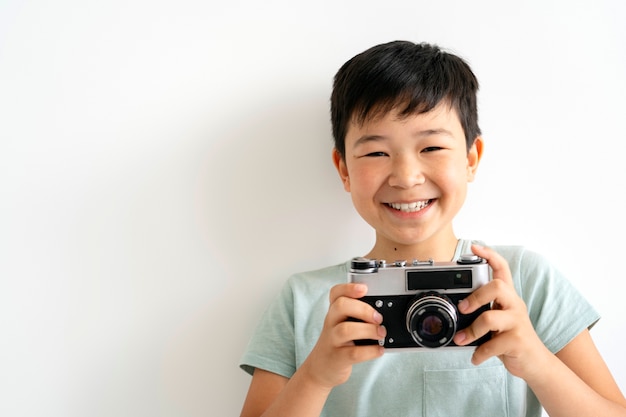 Front view smiley kid holding camera