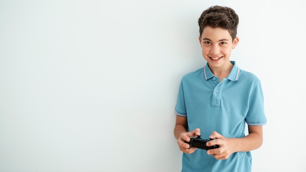 Front view smiley kid playing with a controller