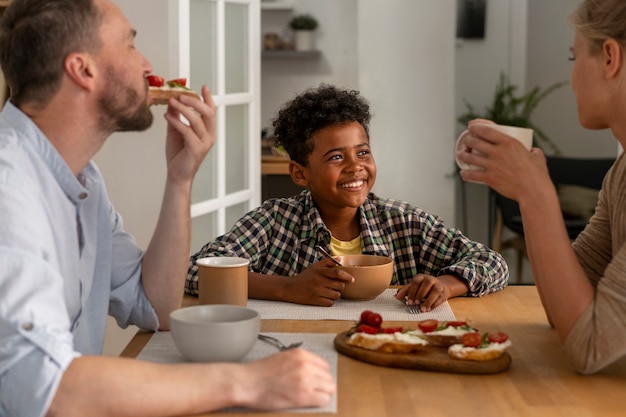 Free photo front view smiley kid sitting at table