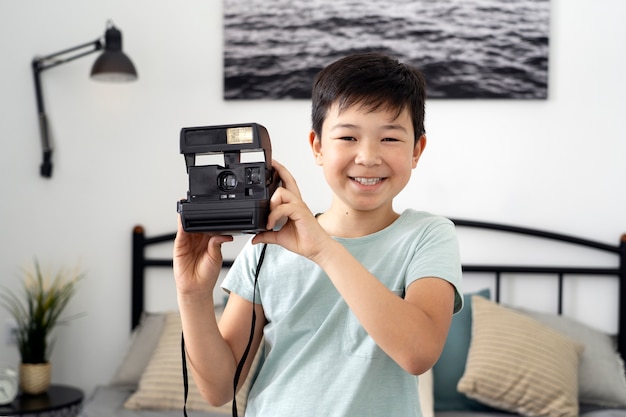 Front view smiley kid taking photos