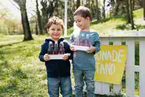 Foto gratuita bambini sorridenti di vista frontale con la limonata