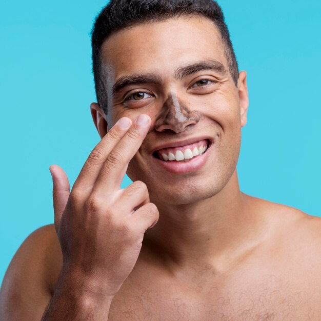 Front view of smiley man applying mask on his nose