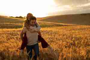 Free photo front view smiley man carrying girlfriend