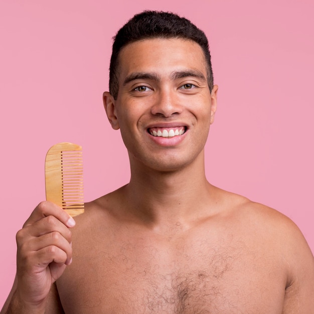 Front view of smiley man holding comb