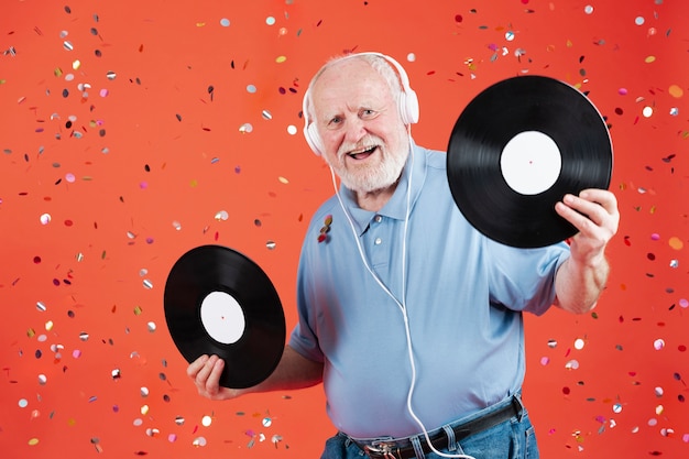 Free photo front view smiley man holding music records